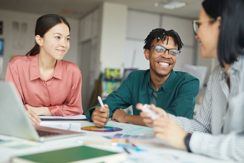 Successful multiethnic business people smiling and discussing during their teamwork at office