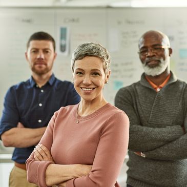 Confident diverse team with arms crossed, smiling at the camera.