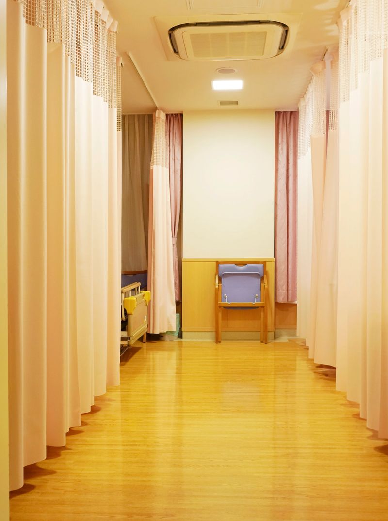 Medical privacy curtain and empty bed in a hospital room
