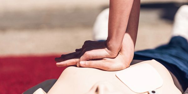 Person performing CPR on a training dummy.