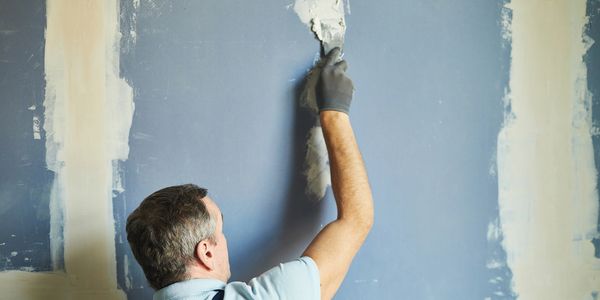 Man applying plaster on a wall.