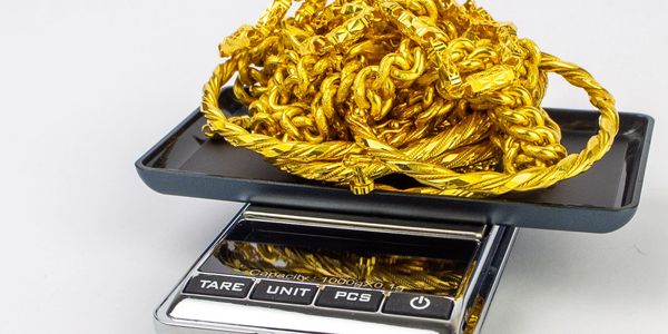 Gold chains being weighed on a digital scale.