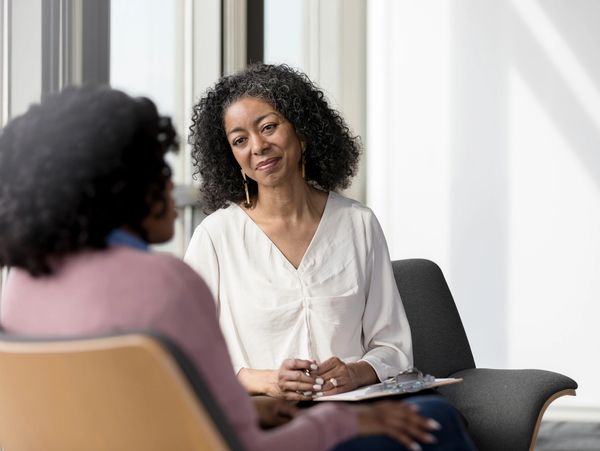 Two women engaged in a thoughtful conversation in a bright room.