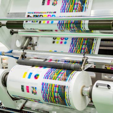 Máquina de impresión en acción con rollos de papel.