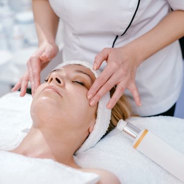 A woman receiving a facial massage in a spa setting.