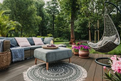 Cozy outdoor seating area with hanging chair and cushions.