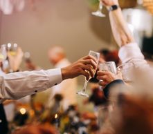 People clinking champagne glasses in a celebratory toast.