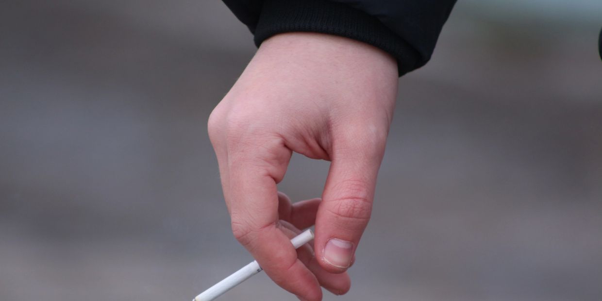 Hand holding a cigarette.