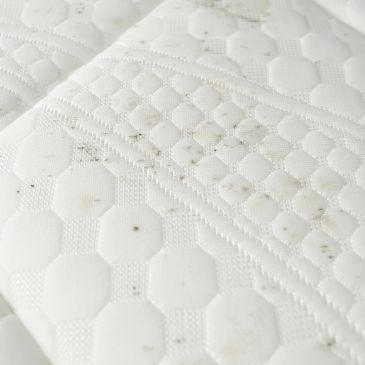 Close-up of a stained white mattress.
