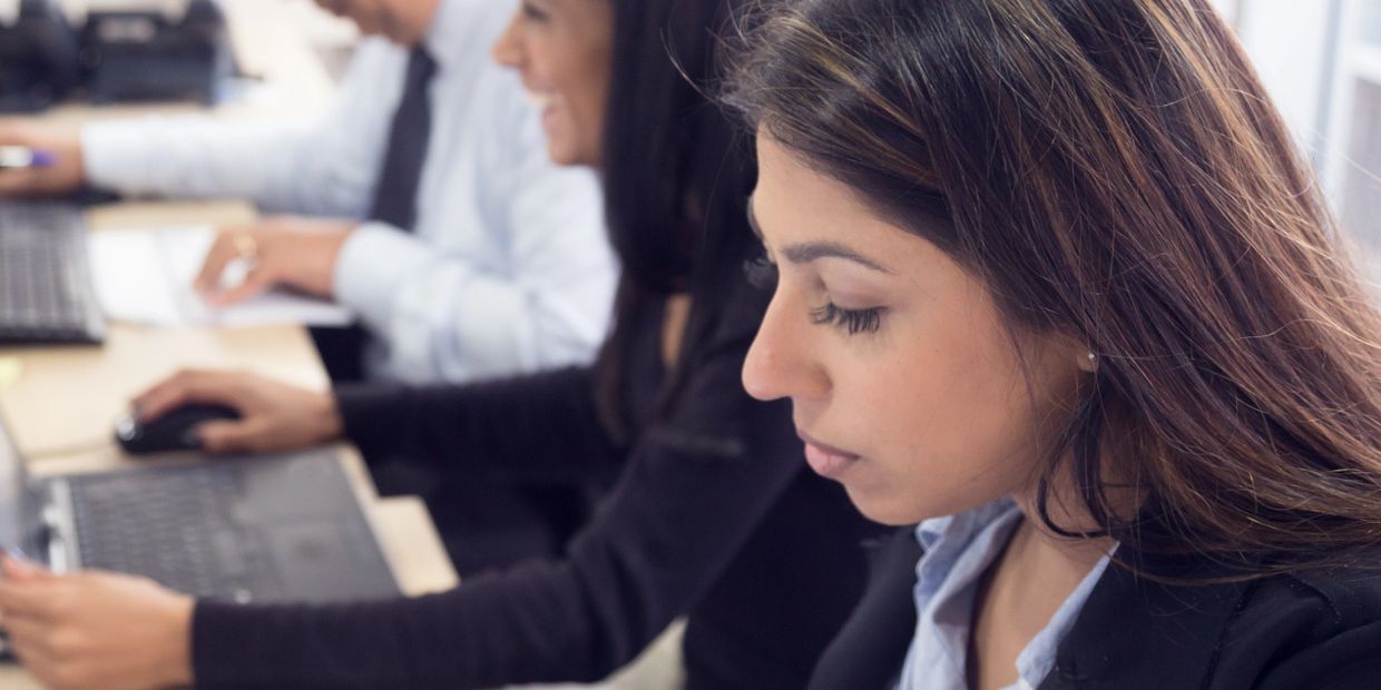 Focused professionals working on computers in an office setting.