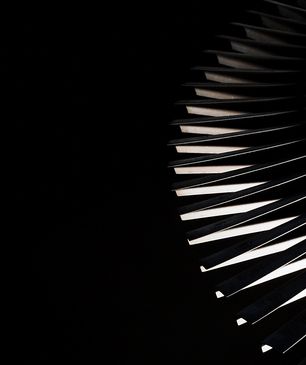 Close-up of piano keys illuminated against a dark background.