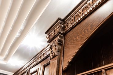 Ornate wooden furniture detail with carved crown molding.