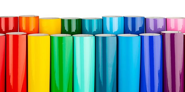 Colorful rolls of vinyl or adhesive film arranged in a row.