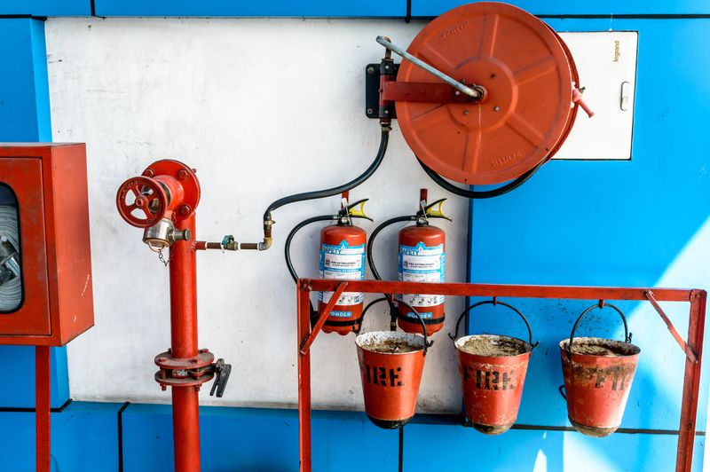 Wall Hanging Fire Extinguisher, Fire Safety and Emergency Equipment install in Red Blue Box wall mount arctural fire extinguisher glass cabinet in a Industrial building.