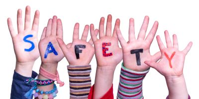 Children's hands with letters spelling SAFETY.