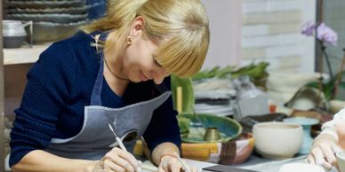 A woman focused on decorating cookies in a kitchen setting.