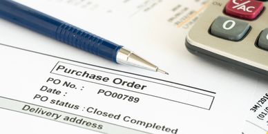 Pen and calculator on a completed purchase order.