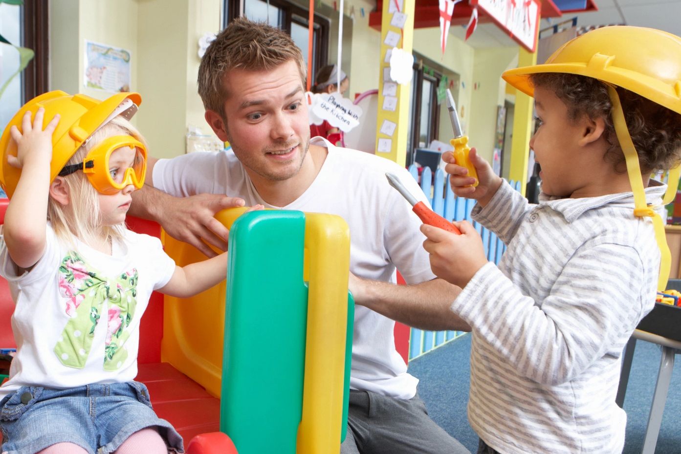 The Early Years Movement | Male Early Years Teacher plays pretend with children dressed as builders.