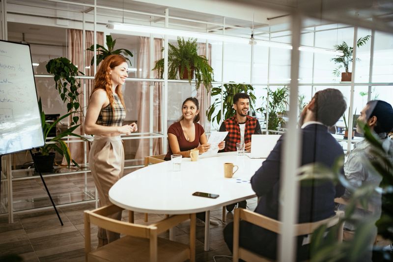 Latin businesswoman in office with colleagues, having presentation of business results