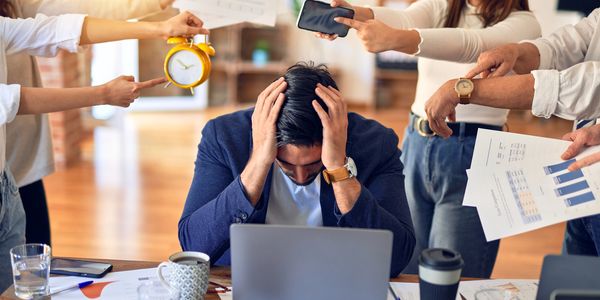 A business owner with his head in his hands looking at a laptop struggling to find funding 