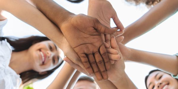 A group of diverse people joining hands in unity and friendship.