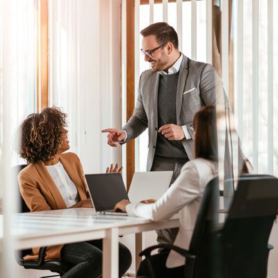 Colleagues sharing a light moment during a meeting in a modern office.
