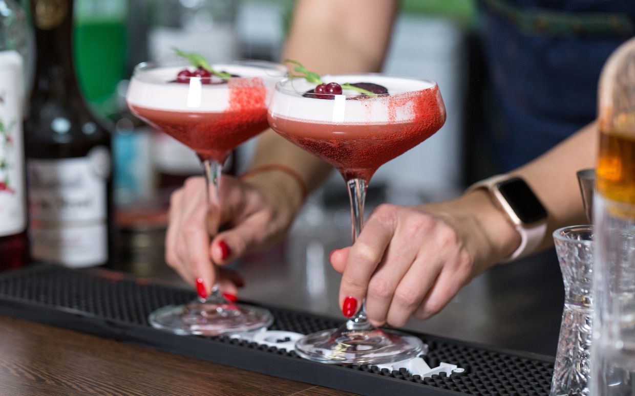 two cocktails being served at the bar