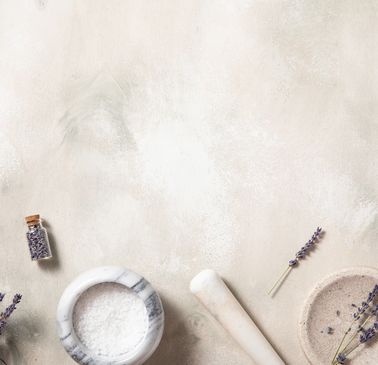 A rustic wooden mortar and pestle with dried flowers and candles for a calming ambiance.