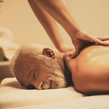 Elderly man receiving a shoulder massage.