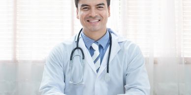 Smiling male doctor in a white coat with a stethoscope.