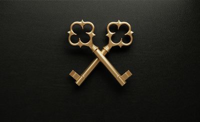 Two ornate golden keys crossed on a black leather background.