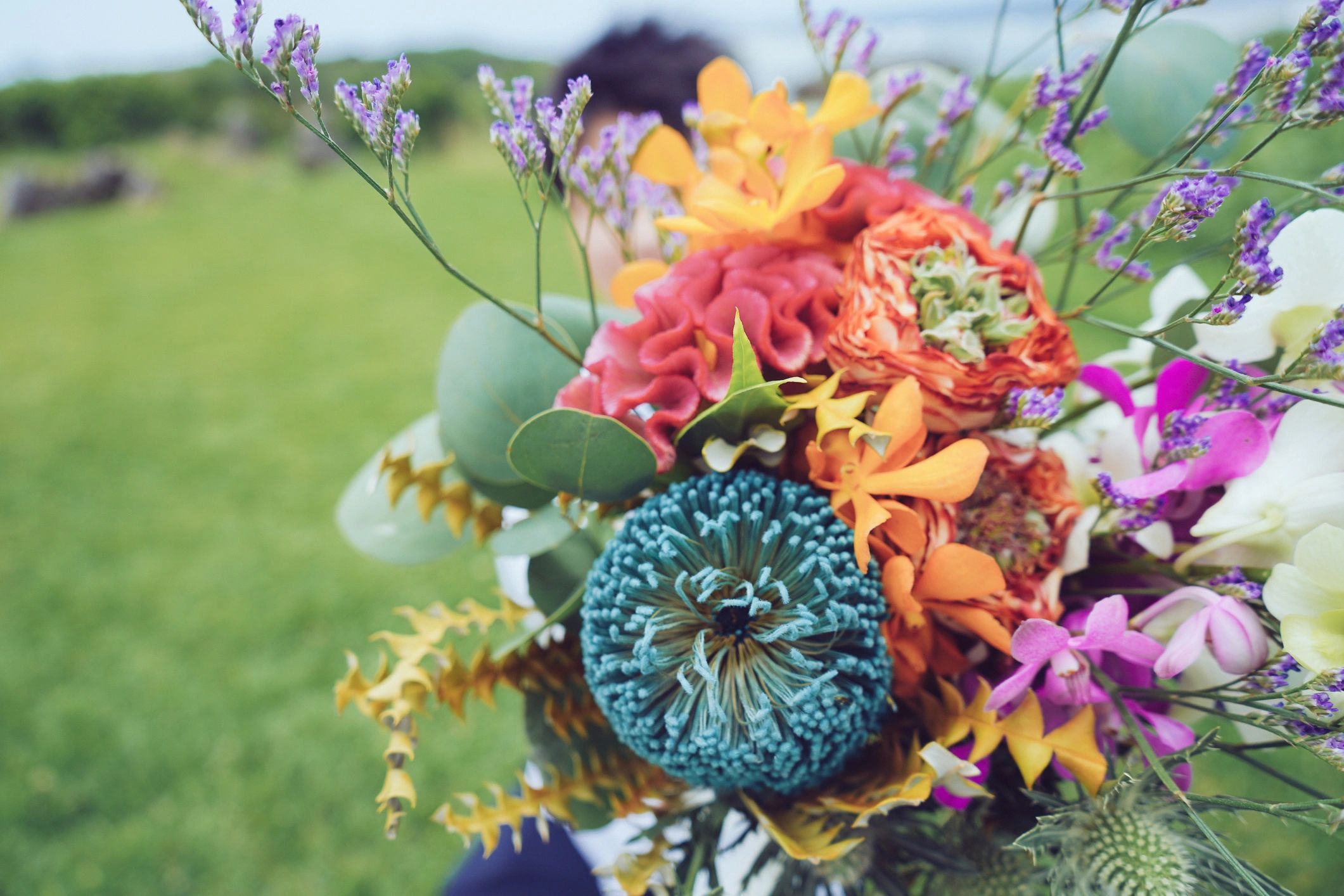 A vibrant bouquet with diverse colorful flowers and greenery.
