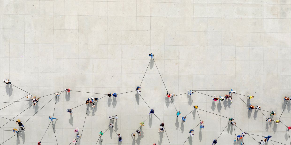 People connected by lines on a concrete surface from above.
