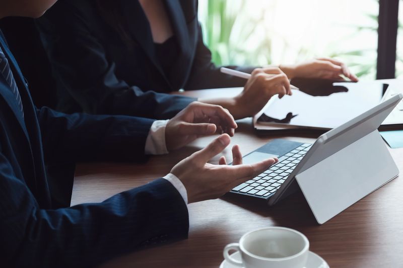 Businessman and business woman discuss to working with using tablet and for searching information stock market chart for trading to Make a profit. Planning and Investment concept.