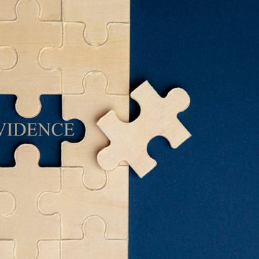 Wooden puzzle piece about to fit into a gap labeled 'EVIDENCE'.