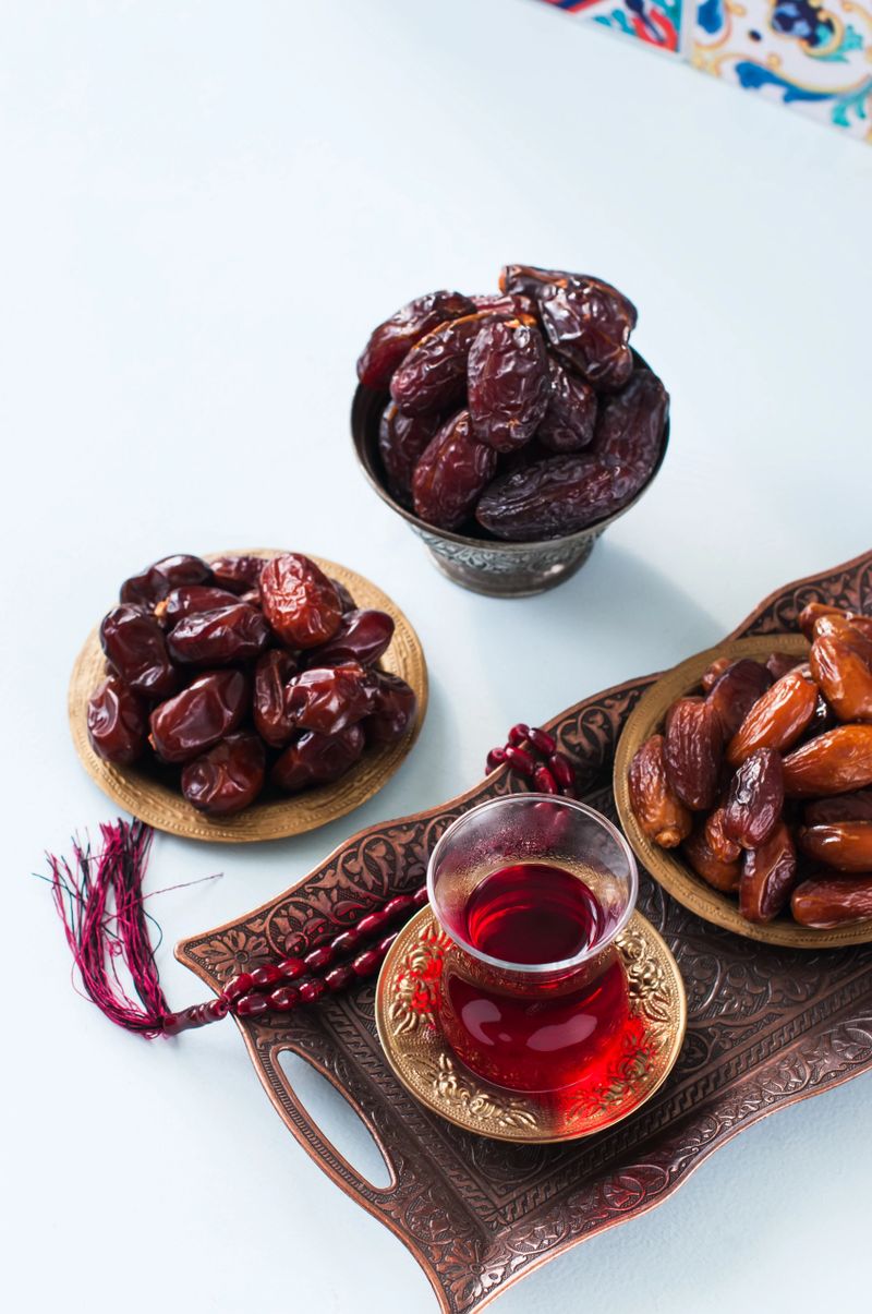 Assorted dried dates or kurma in a vintage plates and tea on a white background.