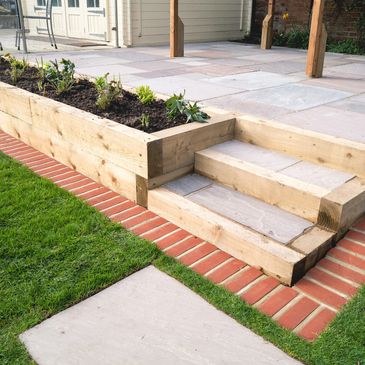 Wooden garden steps with planter box on patio.