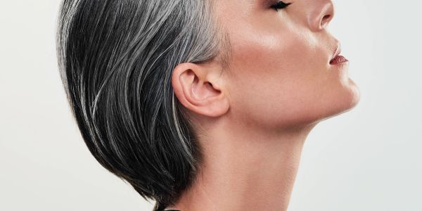 Perfil de mujer con cabello corto y canoso.