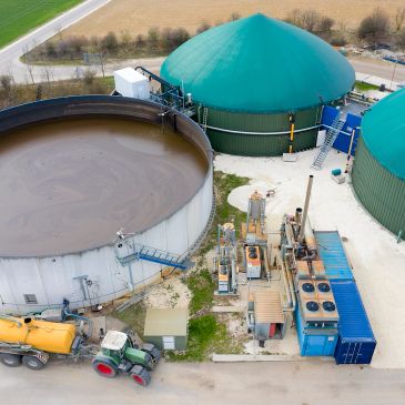 Aerial view of a biogas plant with large tanks and machinery.