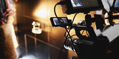 Professional video camera setup with lighting in a studio.