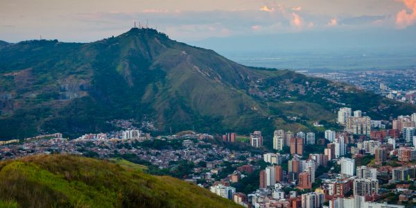 Cityscape with mountain backdrop during sunset.
