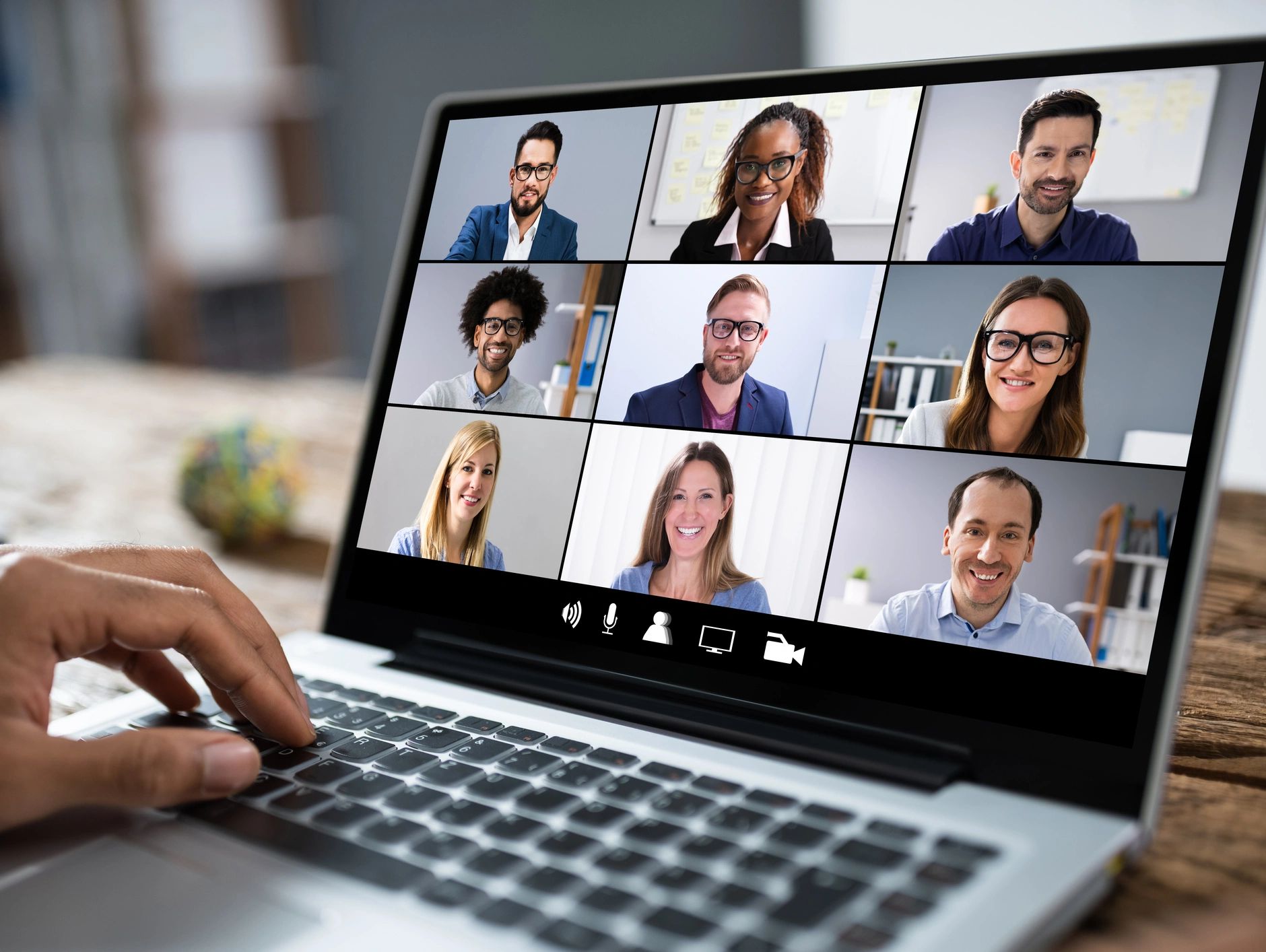 Image: open laptop computer showing 9 people meeting online. 