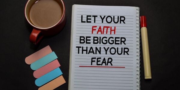 Notebook with motivational quote, coffee cup, and colorful sticky tabs.