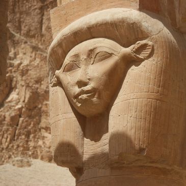 Ancient Egyptian stone carving of a face with a headdress.