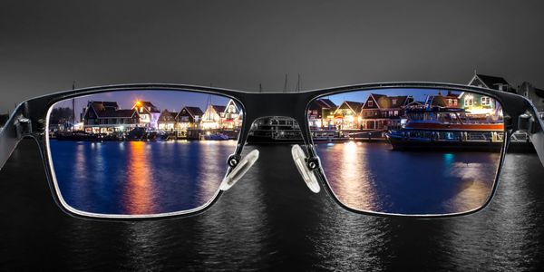 View of waterfront houses through eyeglasses at night.