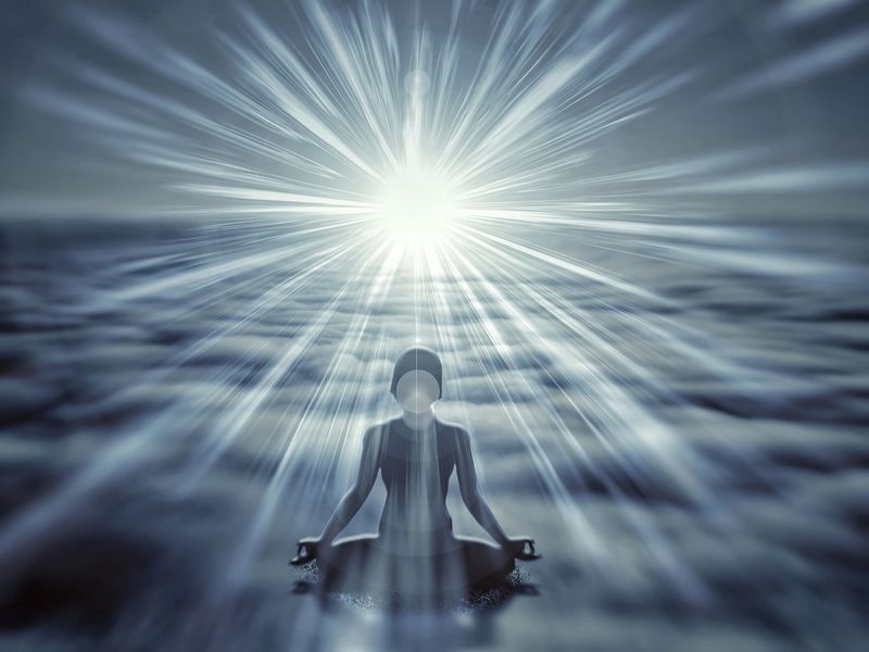 Person meditating in the morning sun