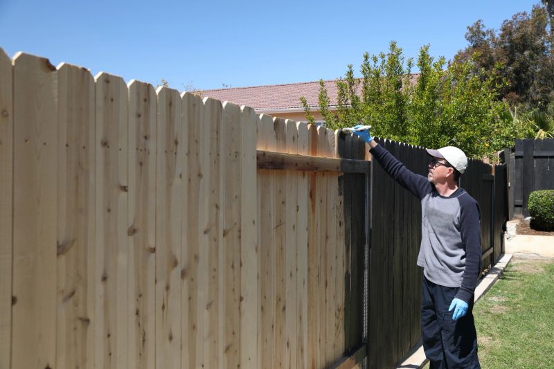 Man paints fence at home. Shot in Moreno Valley, California in March of 2020.