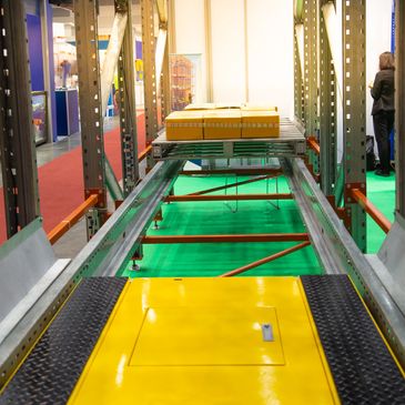 Automated conveyor system transporting yellow packages in a warehouse.