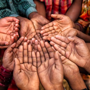 Multiple open hands of diverse individuals together in a circle.