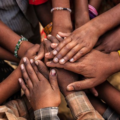 Multiple hands stacked together symbolizing unity and support.